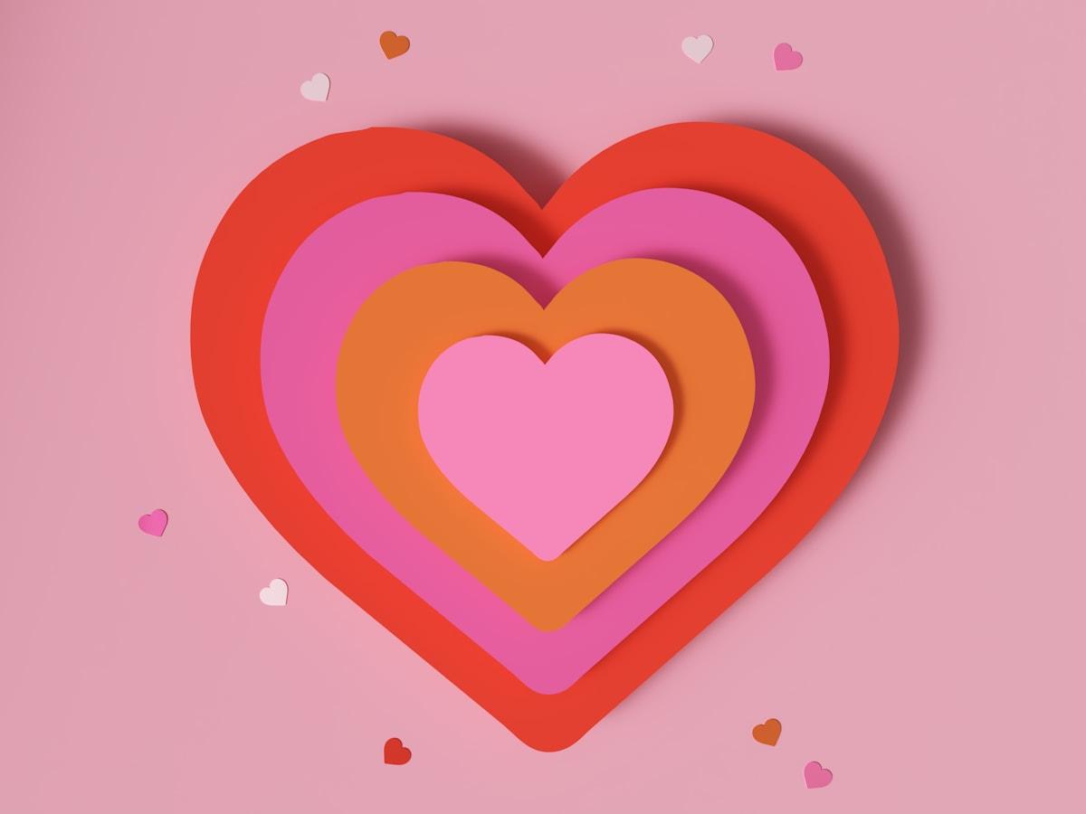 Layered paper hearts on a pink background