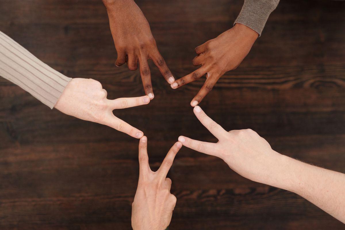 A group of hands forming a star together