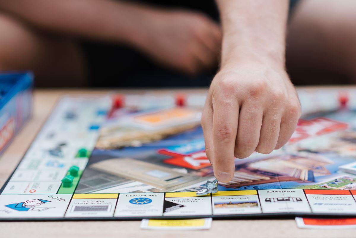 A hand moving a piece on a colorful board game