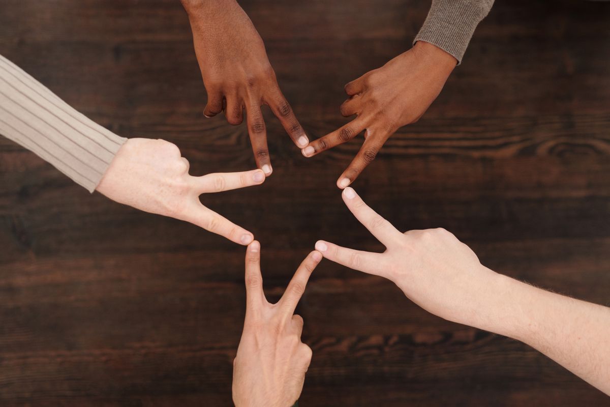 A group of hands forming a star together