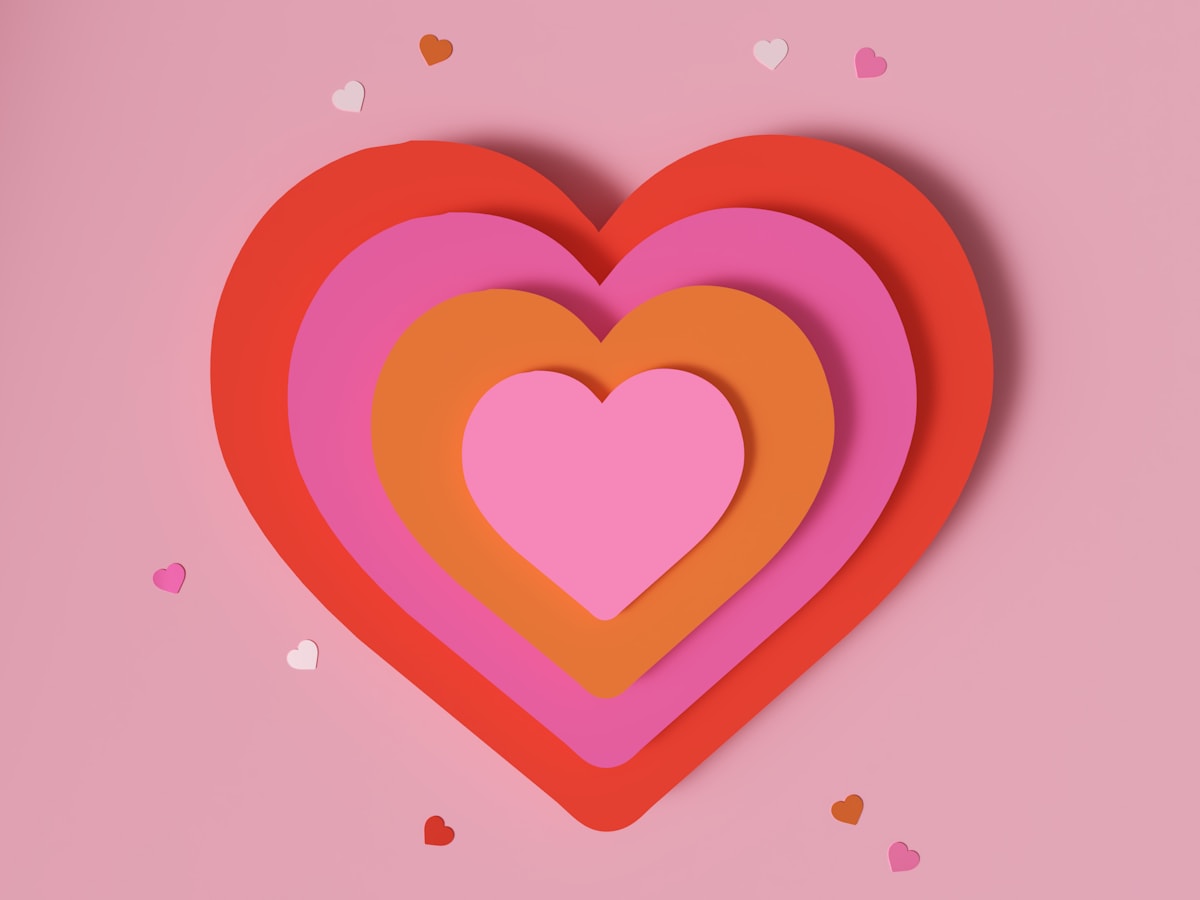 Layered paper hearts on a pink background